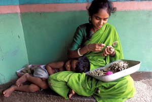 photo of woman in green with child leaning against her lap