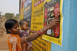 Indian mother and child look at poster with nutrition information